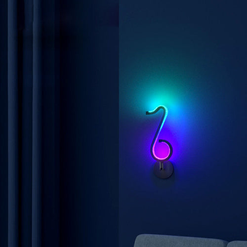 A neon light shaped like a musical clef on a dark blue wall.