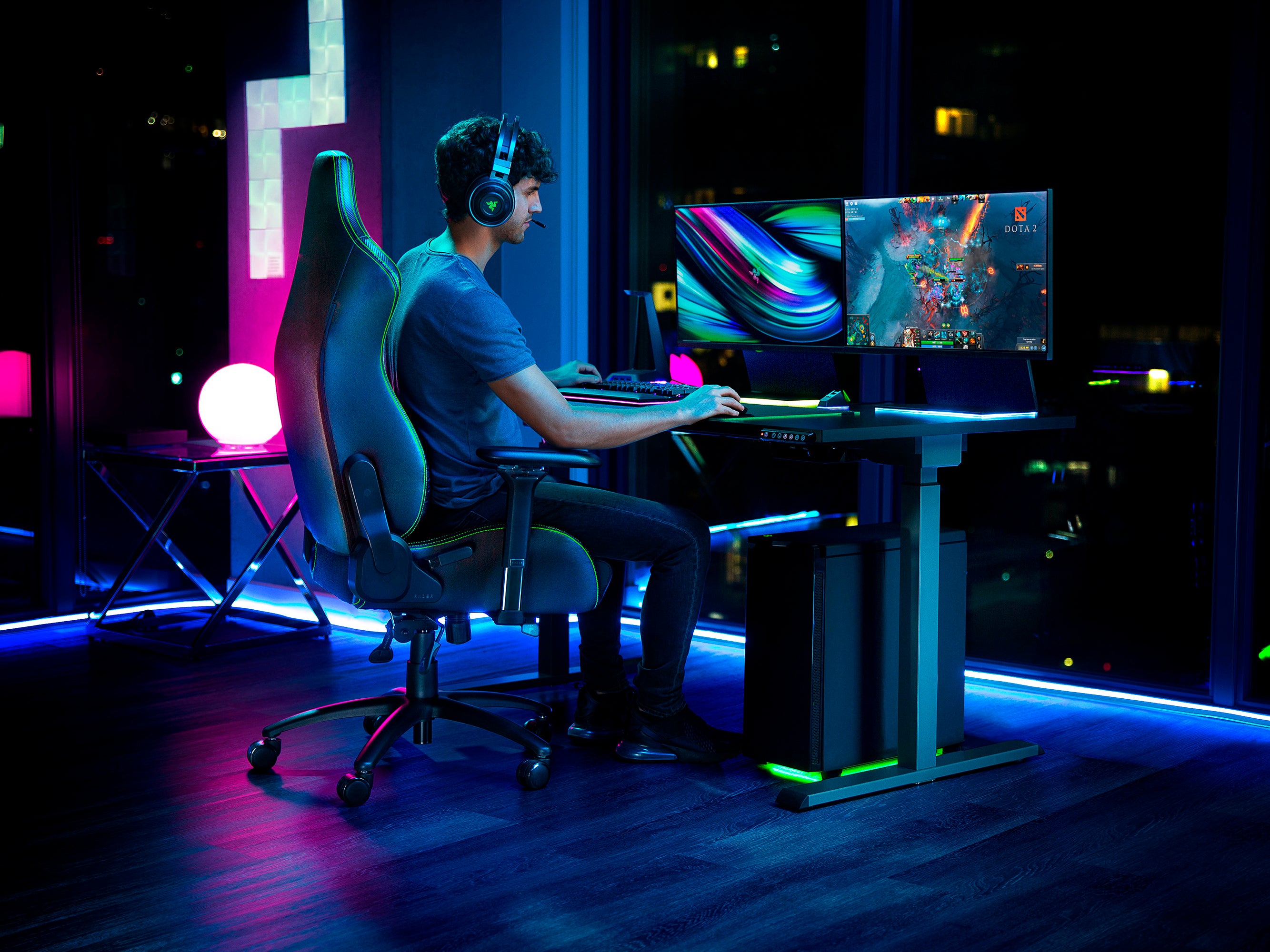 Person playing a video game in a dark room with colorful lighting